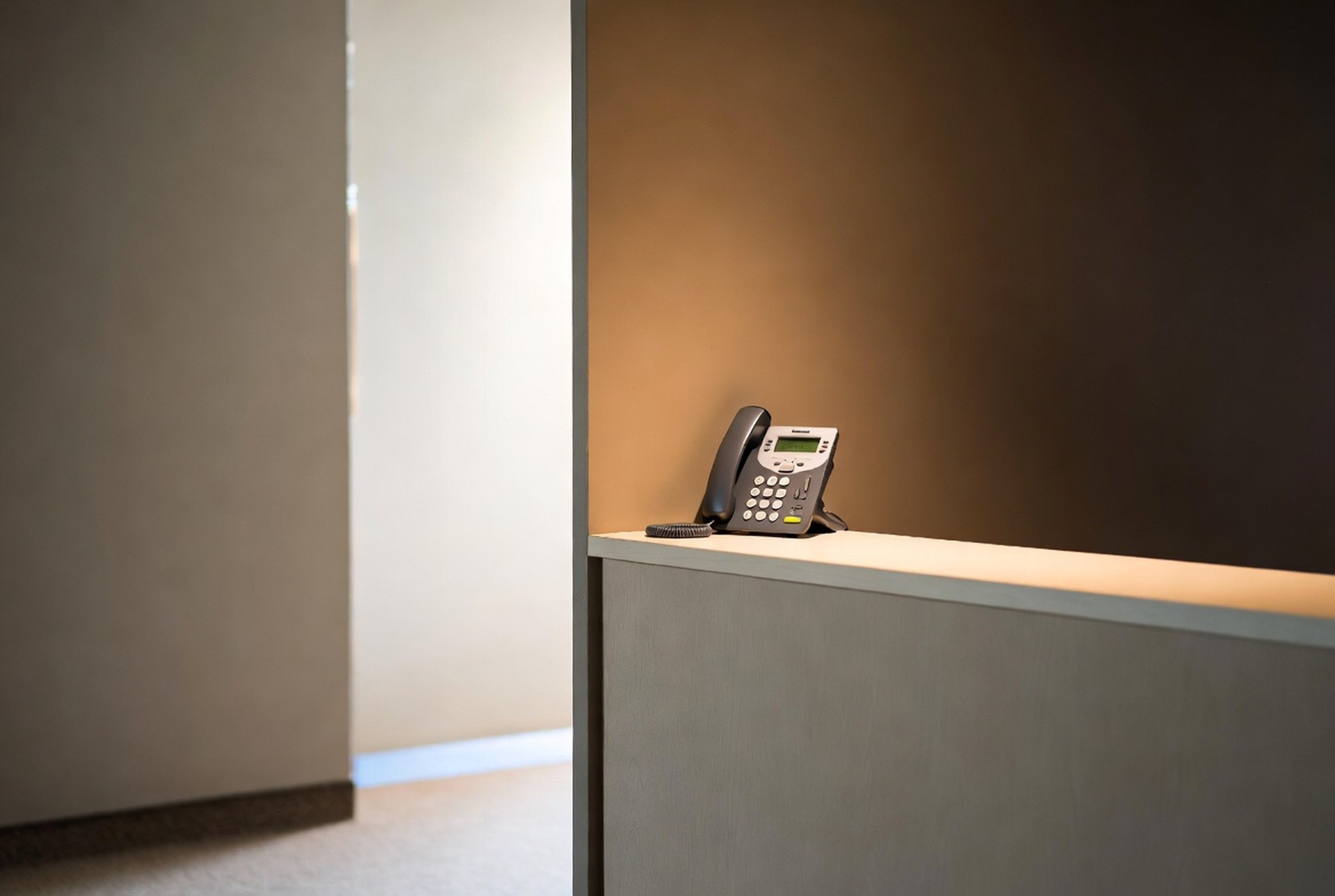 A welcoming reception counter with a wall-mounted IP phone