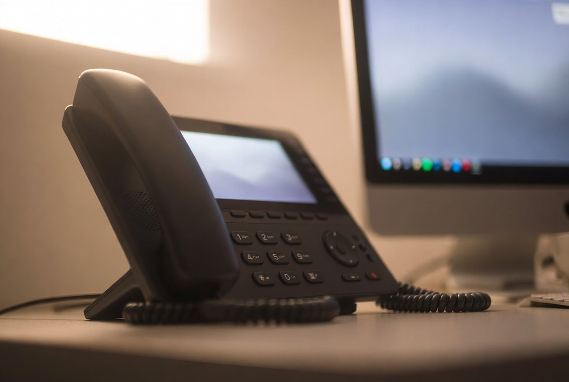IP desk phones on a school front-office desk connected to a hosted PBX