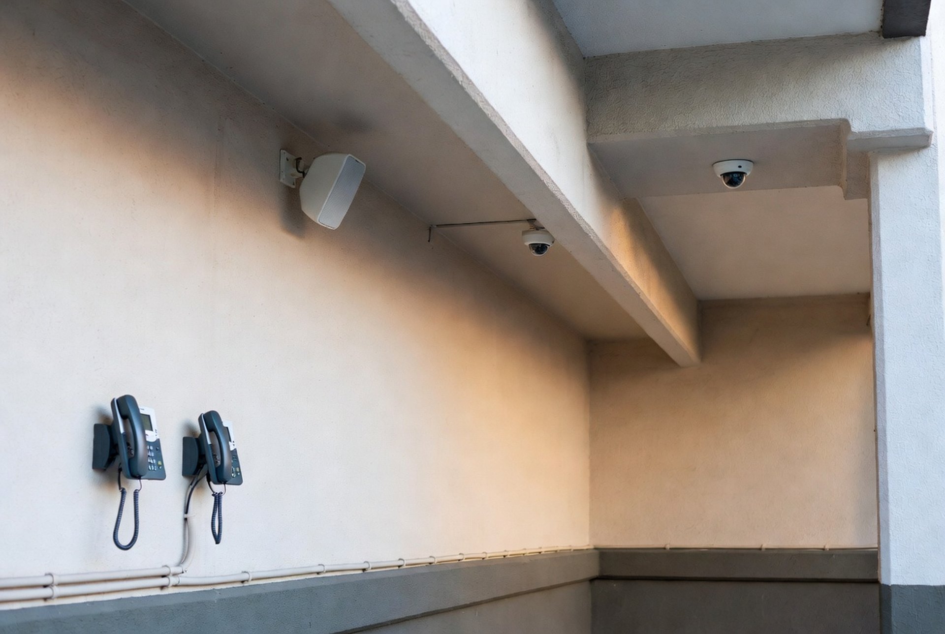 An IP phone, camera dome, and paging speaker together in one corridor
