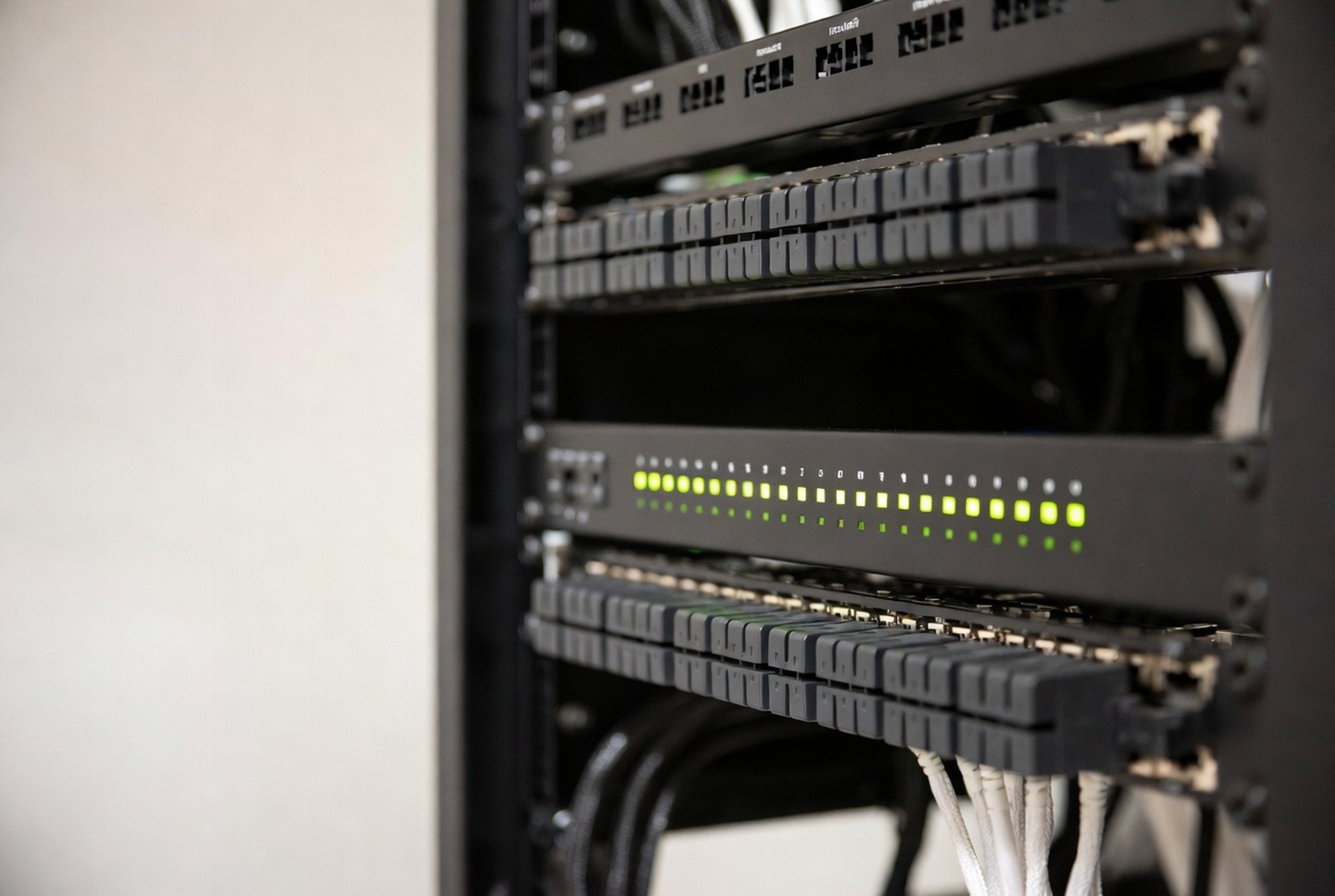 A rack-mounted voice gateway with status LEDs in a network rack